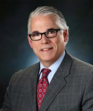 A man in a suit and tie wearing glasses.