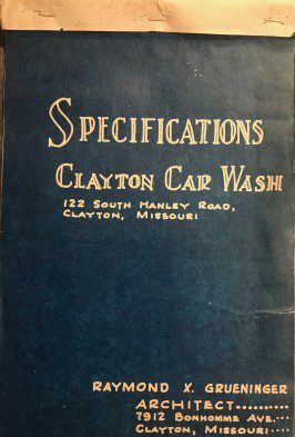 A blue book with the words specifications clayton car wash written in gold lettering.